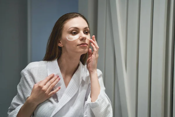 Lady moisturizing her skin under the eyes — Stock Photo, Image