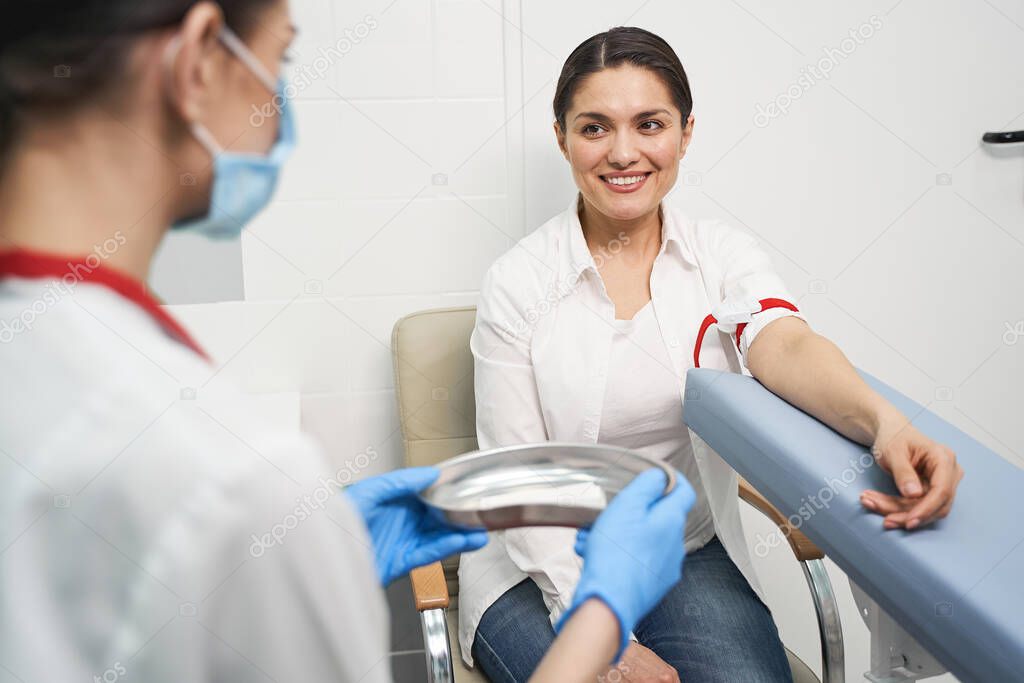 Delighted brunette girl looking at her doctor