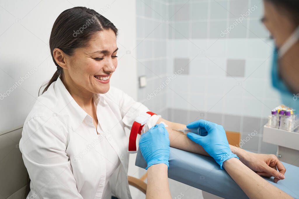 Emotional young woman giving sample of her blood