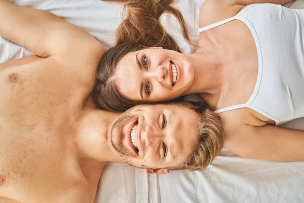 Draufsicht auf junge Leute, die im Bett liegen — Stockfoto