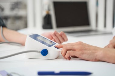 Tonometre kullanan kadın elini kapat.