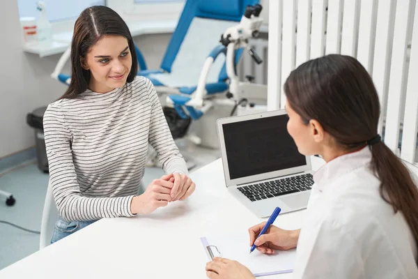 Freundliche Brünette sitzt vor ihrem Arzt — Stockfoto