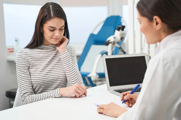 Young longhaired woman listening to her doctor — Stock Photo, Image