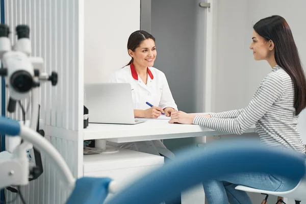 Positiv erfreute junge Ärztin, die ihre Patientin beriet — Stockfoto