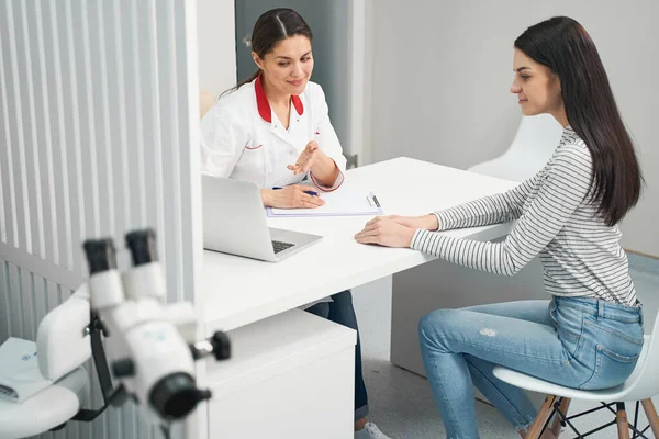 Jovem morena gentil visitando seu médico — Fotografia de Stock