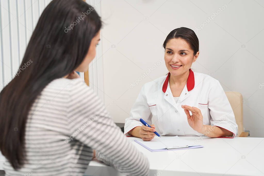 Positive delighted brunette woman working in clinic