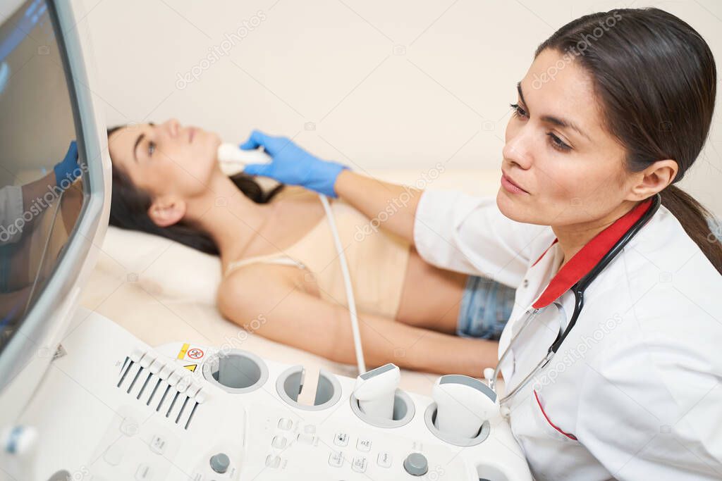 Concentrated young medical worker doing ultrasound checkup