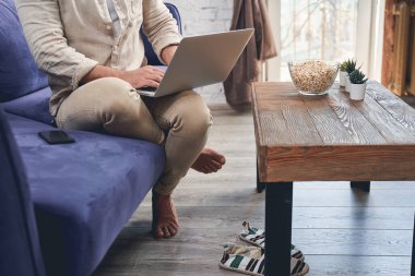 Karantina altındaki bir adam bilgisayarını evde kullanıyor.