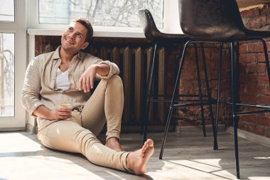 Neşeli Kafkasyalı erkek yerde dinleniyor.