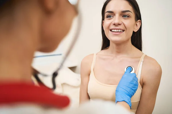 Cheerful brunette female listening to her doctor — Stock Photo, Image