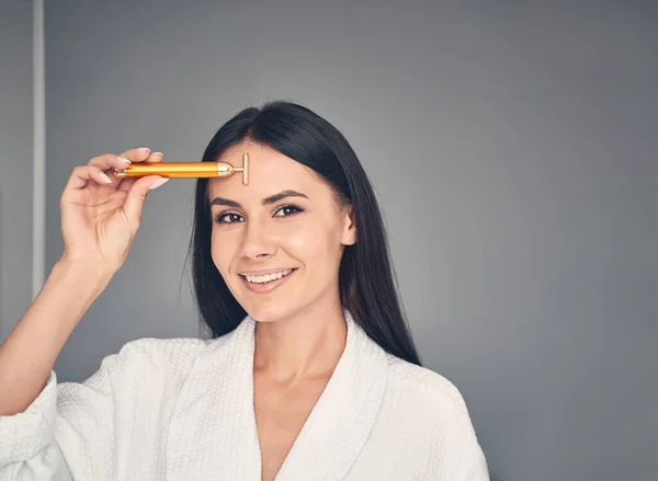 Chica atractiva con un masajeador mirando hacia el futuro — Foto de Stock