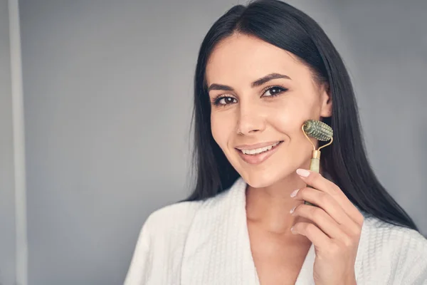 Relajada chica dándose un masaje facial — Foto de Stock