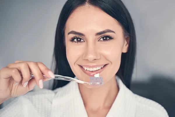 Mujer bonita sosteniendo un cepillo de dientes en su mano — Foto de Stock