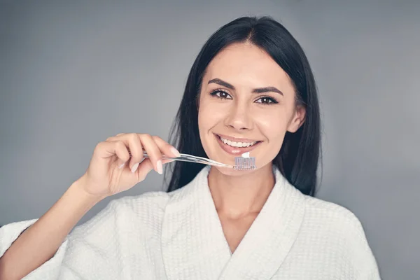 Happy Caucasian young female brushing her teeth — Stock Photo, Image