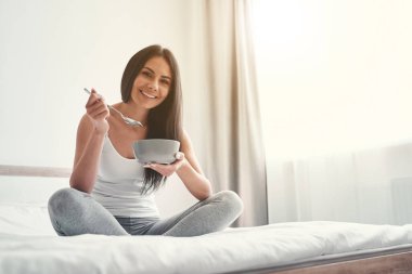 Mutlu kadın kahvaltısını yatak odasında yapıyor.