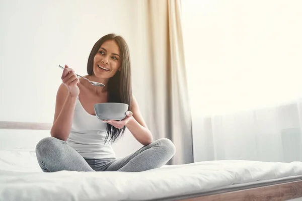 Agradable chica de pelo largo disfrutando de su desayuno saludable — Foto de Stock