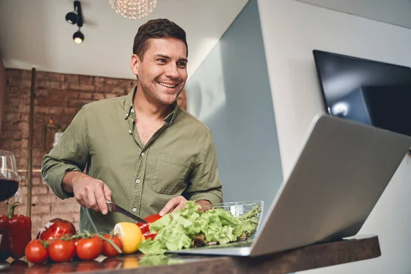 Sonriente hombre caucásico preparando un plato de verduras —  Fotos de Stock