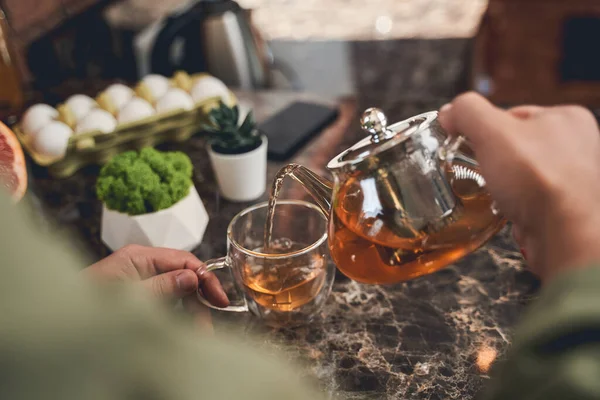 Mannelijke brouwen zwarte thee in de keuken — Stockfoto