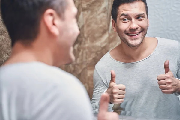 Pleased Caucasian male standing in a bathroom — Stock Photo, Image