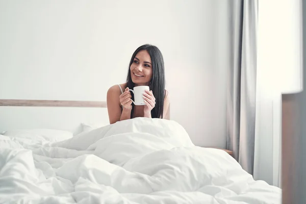 Positivo encantado chica de pelo largo beber té caliente — Foto de Stock