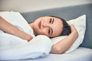 Beyaz tenli çekici kadın yatak odasında dinleniyor.