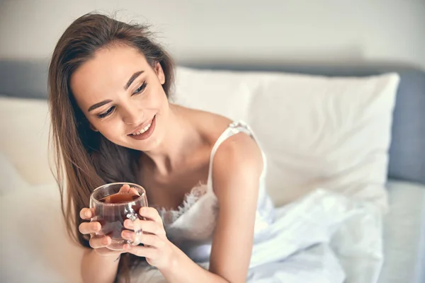 Caucásico feliz mujer teniendo descanso y sosteniendo taza en brazos — Foto de Stock