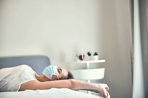 Relajada jovencita acostada en una cama grande en su dormitorio luminoso — Foto de Stock