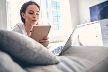 Beyaz tenli zeki bayan öğrenci evden ders çalışıyor.