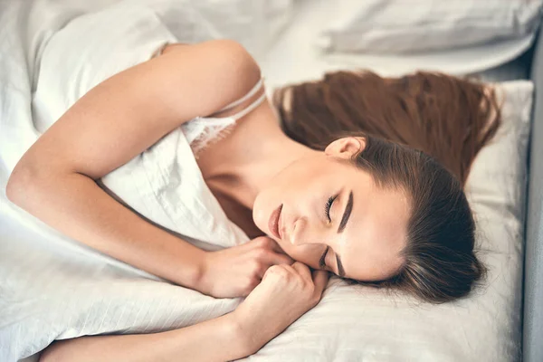 Привлекательная кавказская женщина спит в спальне дома — стоковое фото