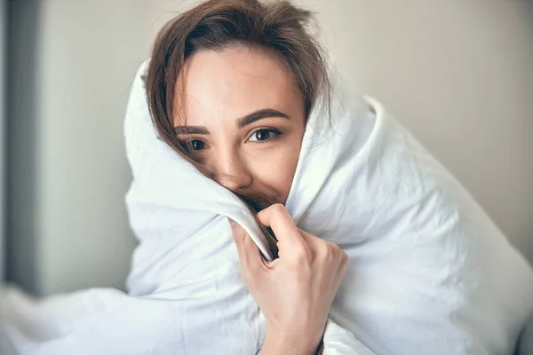 Kaukasische fröhliche Frau versteckt sich am Morgen unter einer Decke — Stockfoto