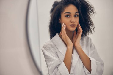 Huzurlu, güzel kız banyoda duruyor.