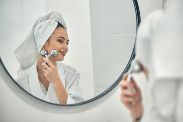 Caucasiano sorridente senhora fazendo massagem facial após banho quente — Fotografia de Stock