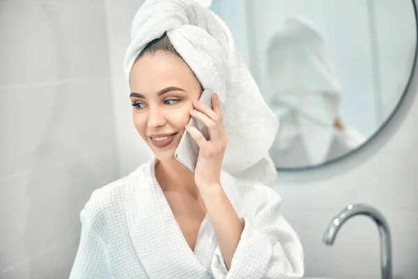 Kaukázusi csinos hölgy fehér köntösben beszél telefonon — Stock Fotó