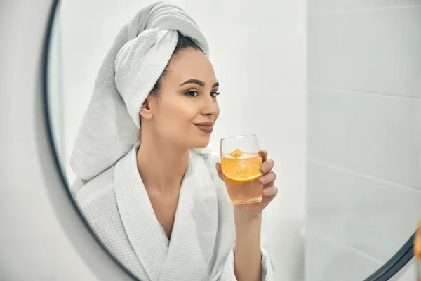Young calm woman enjoying beverage after bath — Stock Photo, Image