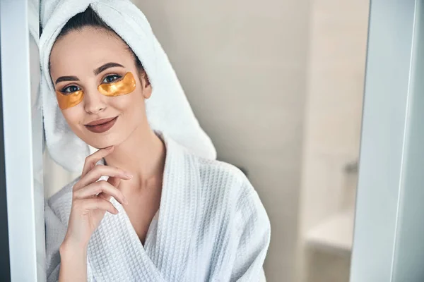 Kaukasische Dame benutzt Pflaster unter den Augen nach dem warmen Bad — Stockfoto