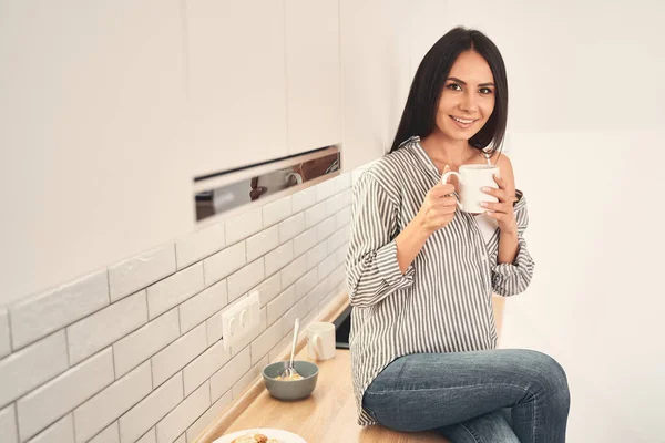 Положительный восторг брюнетка женщина наслаждается чаем — стоковое фото