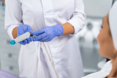 Doktor elinde bir hidroterapi aleti tutuyor.