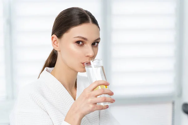 Mujer sosteniendo un vaso de agua de limón — Foto de Stock