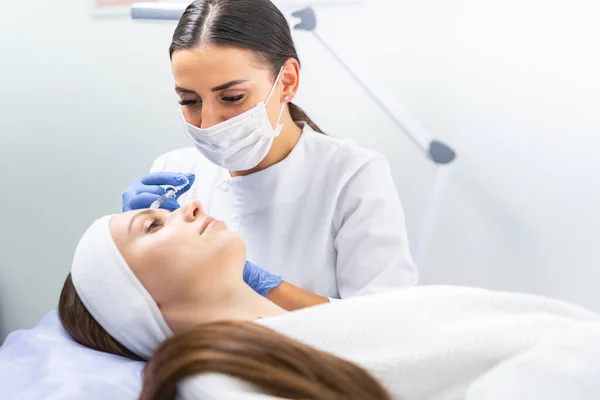 Dermal filler being injected into a patient forehead — Stock Photo, Image