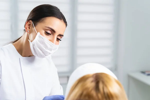 Médico concentrado mirando a su paciente femenino — Foto de Stock