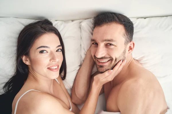 Ehepaar liegt auf Kissen im Bett — Stockfoto