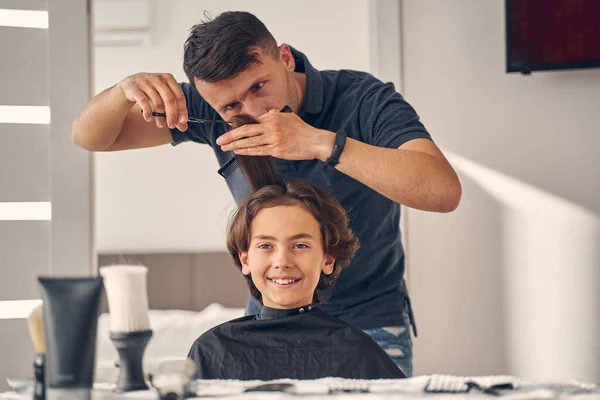 Homem olhando cuidadosamente para o cabelo de criança pequena — Fotografia de Stock