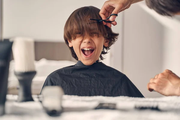 Pequeno garoto desfrutando muito mudando seu penteado — Fotografia de Stock