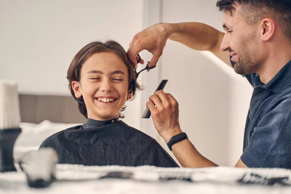 Pequeno menino rindo enquanto recebendo novo corte de cabelo — Fotografia de Stock