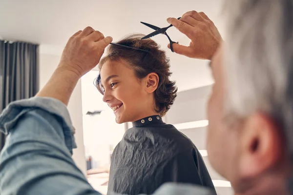 Cutie pequeño niño sonriendo mientras que conseguir nuevo peinado — Foto de Stock