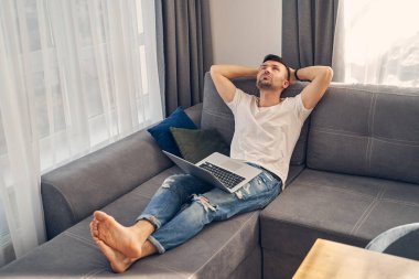 Yakışıklı, şık bir erkek faytonda yatıyor.