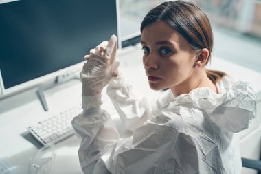 Steril eldivenli çekici bayan ofiste çalışıyor.