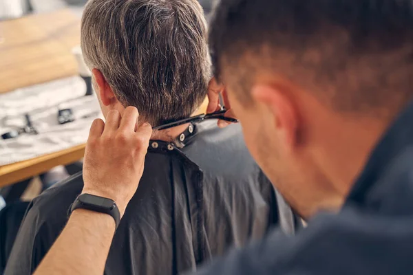 Bruneta s hodinkami stříhání vlasů jiné osoby — Stock fotografie