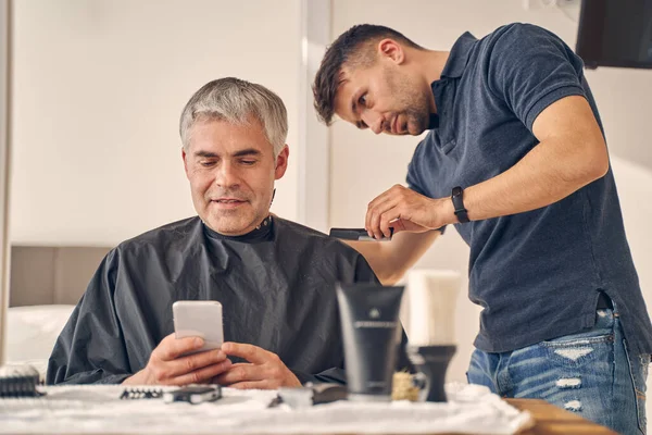 Morena cara mudando penteado de homem maduro — Fotografia de Stock