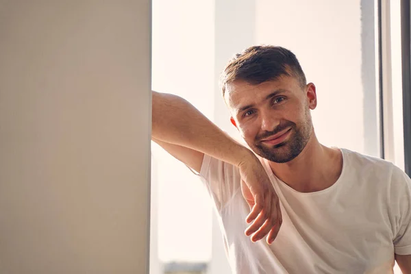 Bonito homem caucasiano sorrindo na câmera dentro de sua casa — Fotografia de Stock